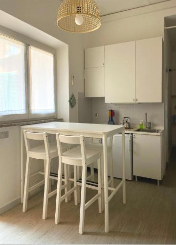 a kitchen with a white table and white chairs at Residence Intur in Marciana Marina
