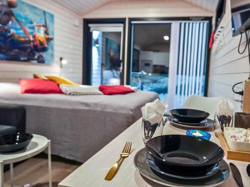 a room with a bed and a table with plates on it at Holiday Home Rakkaranta a- lentäjän poika 1 by Interhome in Hyrynsalmi