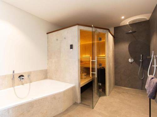 a bathroom with a bath tub and a shower at Holiday Home Fischer sien Huus-6 by Interhome in Fedderwarderdeich