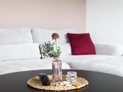 a table with a vase with a flower on it at Holiday Home Fischer sien Huus-6 by Interhome in Fedderwarderdeich