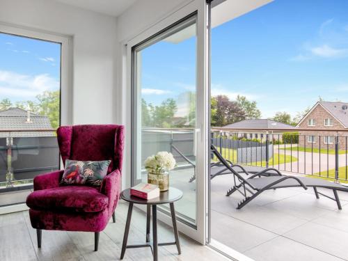 a living room with a purple chair and a table at Holiday Home Fischer sien Huus-6 by Interhome in Fedderwarderdeich