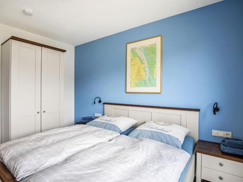 two beds in a bedroom with blue walls at Holiday Home Fischer sien Huus-6 by Interhome in Fedderwarderdeich