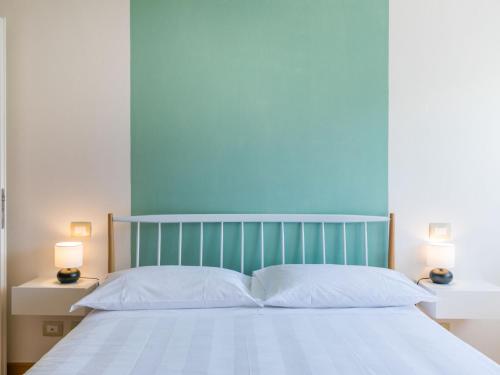 a bed with a blue headboard and white pillows at Apartment Casa del Sole by Interhome in Castelnuovo dellʼAbate