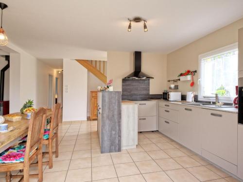 a kitchen with white cabinets and a table and a dining room at Holiday Home Chez Lucie by Interhome in Camlez