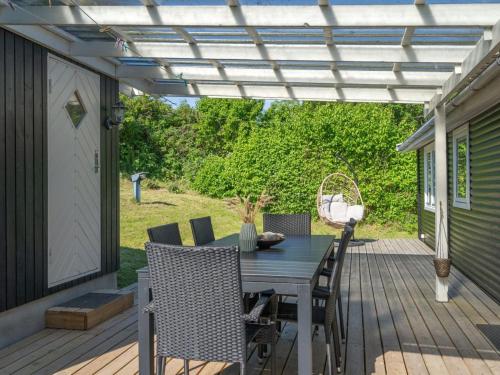 a patio with a table and chairs on a deck at Holiday Home Felis - 75m from the sea by Interhome in Martofte