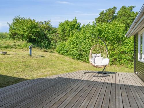 a wicker chair sitting on a wooden deck at Holiday Home Felis - 75m from the sea by Interhome in Martofte