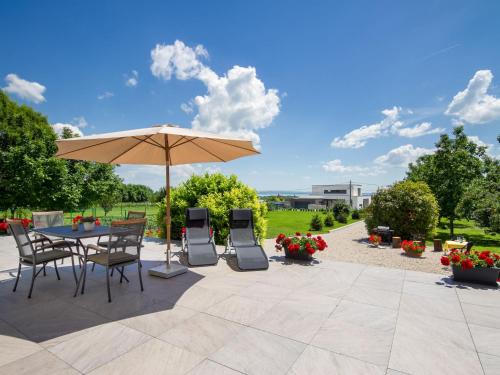 a patio with a table and chairs and an umbrella at Apartment Cserszeg by Interhome in Cserszegtomaj
