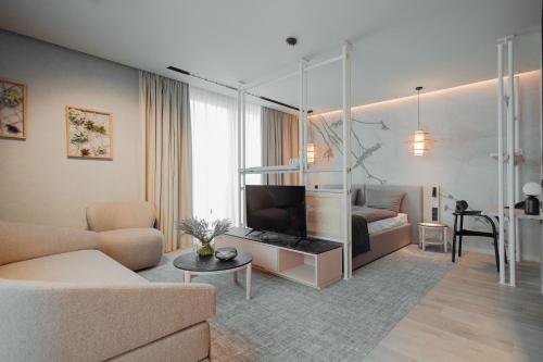 uma sala de estar com um sofá e uma televisão em Hygge Hotel em Opole