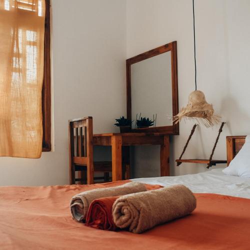 a bedroom with a bed with a mirror and a desk at Salty Alchemy in Arugam Bay