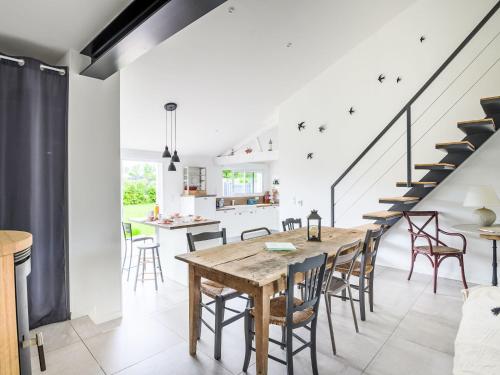 une cuisine et une salle à manger avec une table et des chaises en bois dans l'établissement Holiday Home Grand confort proche Océan by Interhome, à Notre-Dame-de-Riez
