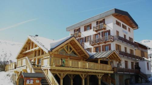 a large wooden building with snow on top of it at Les Neiges in Saint-Sorlin-dʼArves