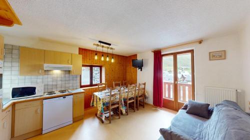 a kitchen and living room with a couch and a table at Les Neiges in Saint-Sorlin-dʼArves