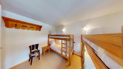 a bedroom with a bunk bed and a chair at Les Neiges in Saint-Sorlin-dʼArves