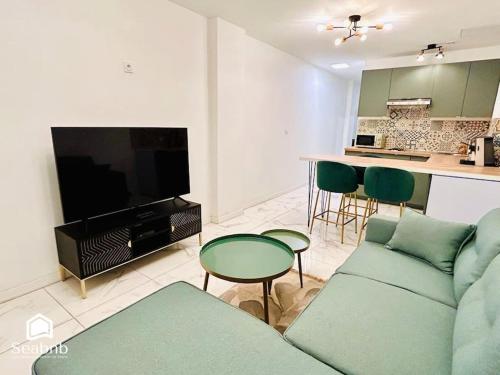 un salon avec un canapé et une télévision et une cuisine dans l'établissement Charming Downtown - AC - WiFi - Private Entrance, à Nice