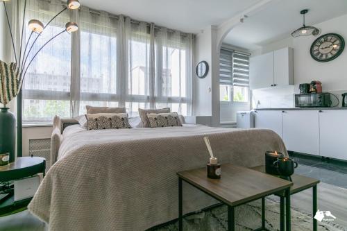 une chambre avec un grand lit et une table dans l'établissement MBA - Jarry Splendide Appart Proche Château de Vincennes, à Vincennes