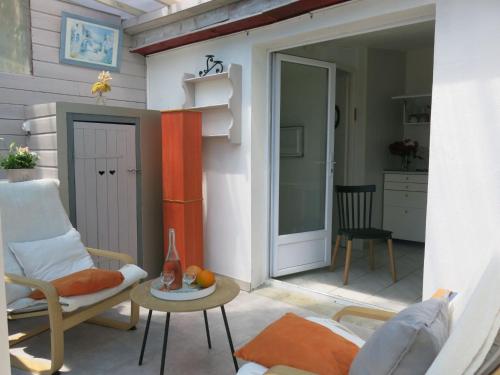 a patio with a chair and a table and a door at Holiday Home Roses Tremières by Interhome in Talmont