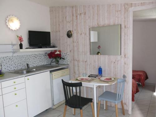 - une cuisine avec une table, un évier et un miroir dans l'établissement Holiday Home Roses Tremières by Interhome, à Talmont-Saint-Hilaire