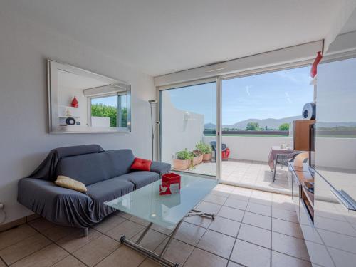 un salon avec un canapé bleu et une table en verre dans l'établissement Apartment Les Embruns-17 by Interhome, à Saint-Cyprien