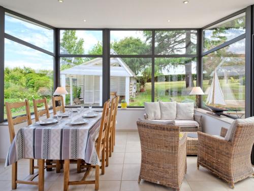 une salle à manger avec une table, des chaises et des fenêtres dans l'établissement Holiday Home Chante-Brise by Interhome, à Plérin