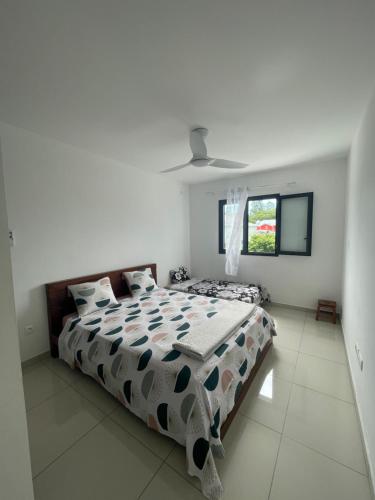 a white bedroom with a large bed and a window at Magnifique villa avec espaces extérieurs in Saint-André