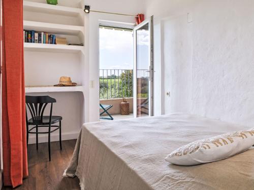 a white bedroom with a bed and a balcony at Holiday Home Maison Gerard by Interhome in Cervione