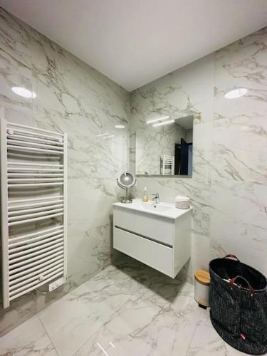 une salle de bain blanche avec un lavabo et un miroir dans l'établissement Sublime T3 neuf vue mer,sanguinaires, plage à pied, à Grosseto-Prugna