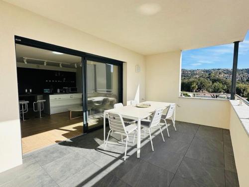 une salle à manger avec une table et des chaises sur un balcon dans l'établissement Sublime T3 neuf vue mer,sanguinaires, plage à pied, à Grosseto-Prugna