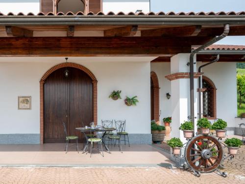 a patio with a wooden door and a table and chairs at Holiday Home Collina San Ponzio by Interhome in Barolo