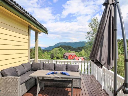 a patio with a couch and an umbrella on a deck at Holiday Home Gule huset by Interhome in Bruntveit