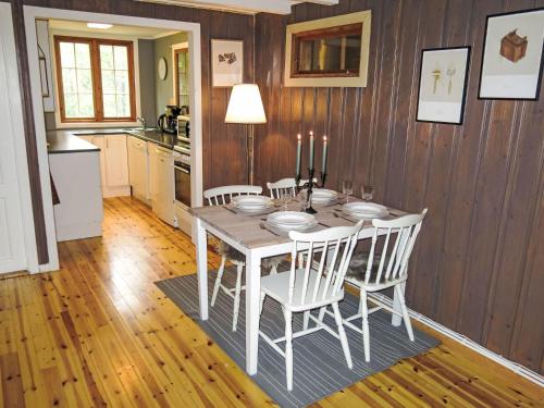 a dining room with a table and chairs and a kitchen at Holiday Home Hustjønn by Interhome in Aamli