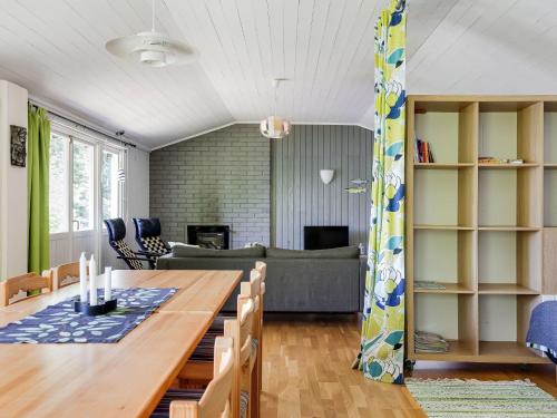 a dining room and living room with a wooden table at Holiday Home Munkhalla Utsikten by Interhome in Asarum