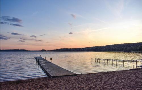 a dock on a body of water at sunset at Gorgeous Home In Hästveda With Kitchen in Hästveda