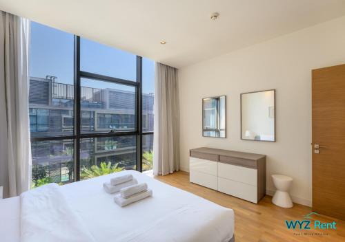 una camera con un letto bianco e una grande finestra di The perfect CityWalk 1 BR in the heart of Dubai a Dubai