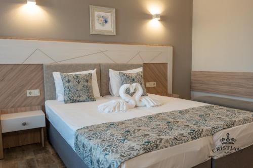 ein Schlafzimmer mit einem Bett mit zwei Handtüchern darauf in der Unterkunft Cristiani Hotel Sozopol in Sozopol