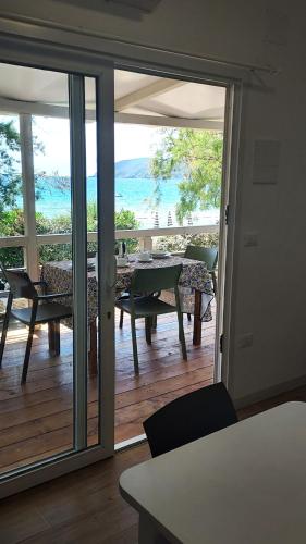a room with a balcony with a table and chairs at Camping Europa in Capoliveri