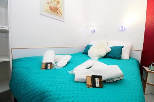 Cette chambre comprend un lit bleu avec des serviettes. dans l'établissement Cannes appartement 4 pers vue mer Wi Fi Climatisation piscine, à Cannes