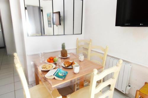 une table en bois avec une assiette de nourriture dessus dans l'établissement Cannes appartement 4 pers vue mer Wi Fi Climatisation piscine, à Cannes