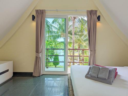 a bedroom with a bed and a large window at Villa with Private Pool - by KohChangVillas in Ko Chang