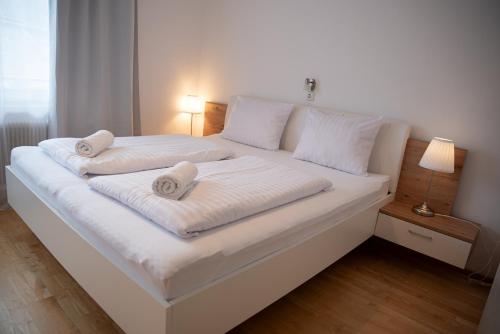 a white bed with two towels on top of it at Haus Maria in Bruck an der Großglocknerstraße