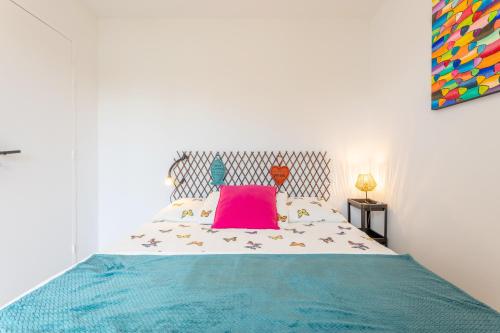 a bedroom with a bed with a pink pillow on it at Appartement - 50m de la mer in Fouesnant