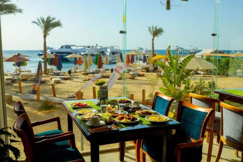 a table with food on it with a view of the beach at Shellghada Blue Beach in Hurghada