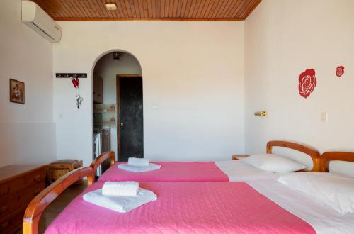 a bedroom with a large bed with a pink blanket at Ulisse Apartments in Paleokastritsa