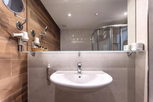 a bathroom with a white sink and a mirror at Hotel Villa Margherita in Limone sul Garda