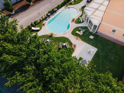 widok na basen z krzesłami i drzewami w obiekcie B&B Podere Dell'Angelo w mieście Pasiano di Pordenone