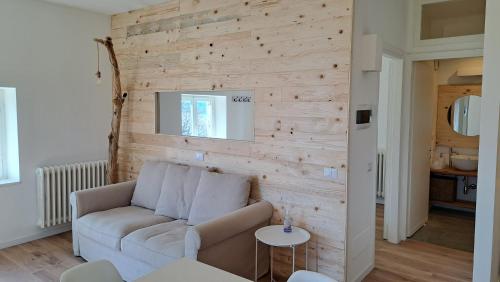 a living room with a couch and a wooden wall at Shambala Home Casa Luna in Someraro
