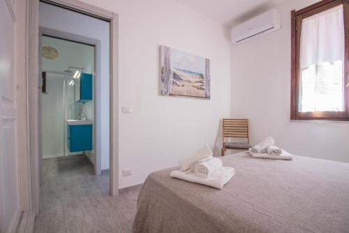 a white room with a bed with towels on it at Palau Lovely Sea View Apartment with Balcony in Palau