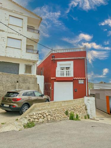 a car parked in front of a red building at Casa Lourdes in Yeste