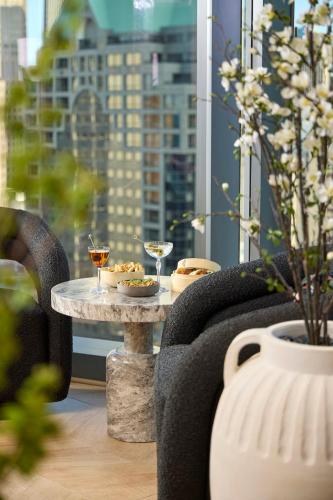 a table with two glasses of wine on it with a window at Viceroy Chicago in Chicago