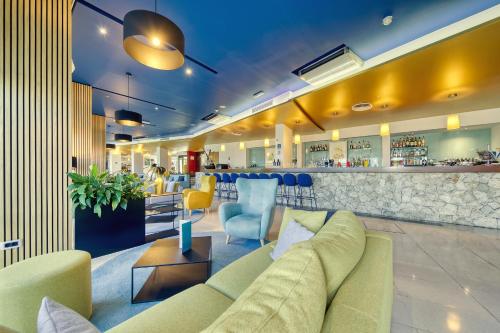a lobby with a couch and a bar at Ilirija Resort Hotel Ilirija in Biograd na Moru