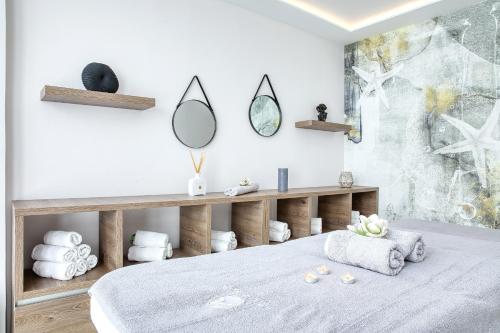 a bedroom with a bed with a mirror and towels at Ilirija Resort Hotel Ilirija in Biograd na Moru